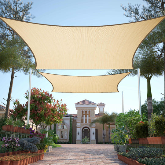 Beige Royal Shade rectangle sun shade sails stretched above a landscaped paved courtyard