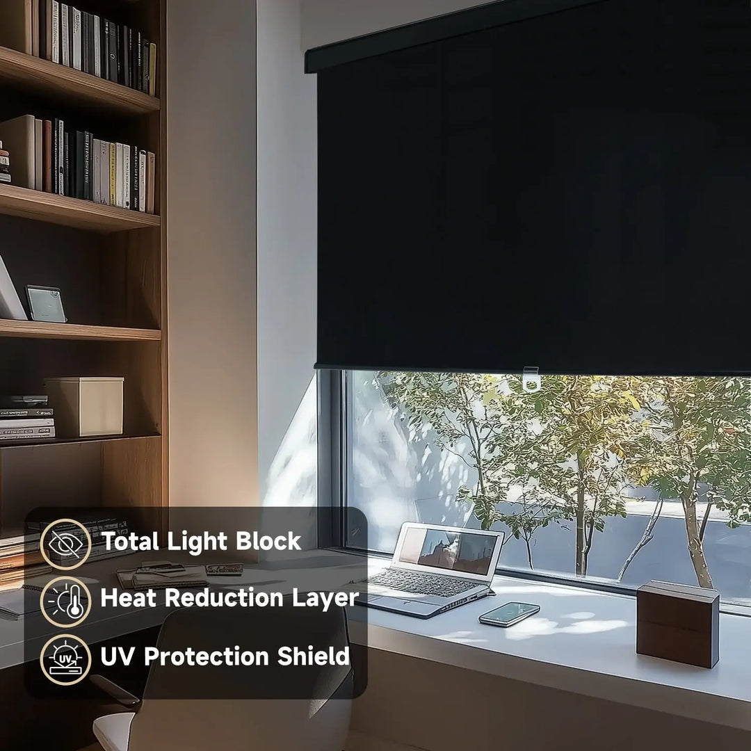 Black blackout roller shade on home-office window beside laptop and bookcase with light-control labels